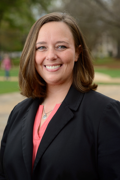 Christie Davis, Director of Joint Communications, smiling and wearing a black blazer over a coral blouse