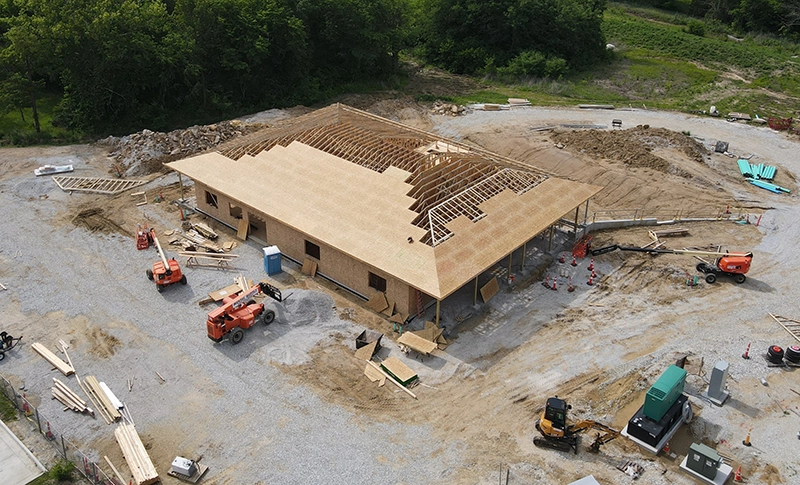 Construction site of the Boone County Early Learning Center, with frame built and sheathing going on the roof.
